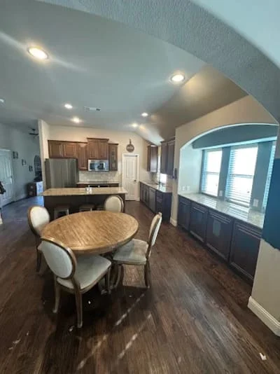 Open concept kitchen and dining room with dark hardwood floors, recessed lighting, and two-tone cabinetry