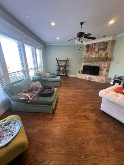 Master bedroom with hardwood flooring, stone fireplace, and recessed ceiling lights